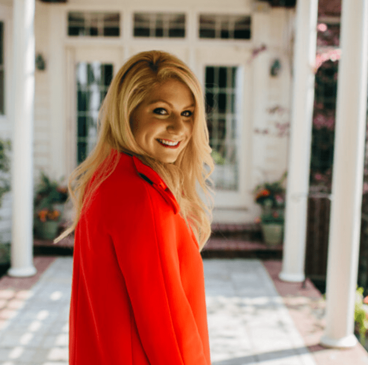 Emily Williams smiling wearing an orange coat