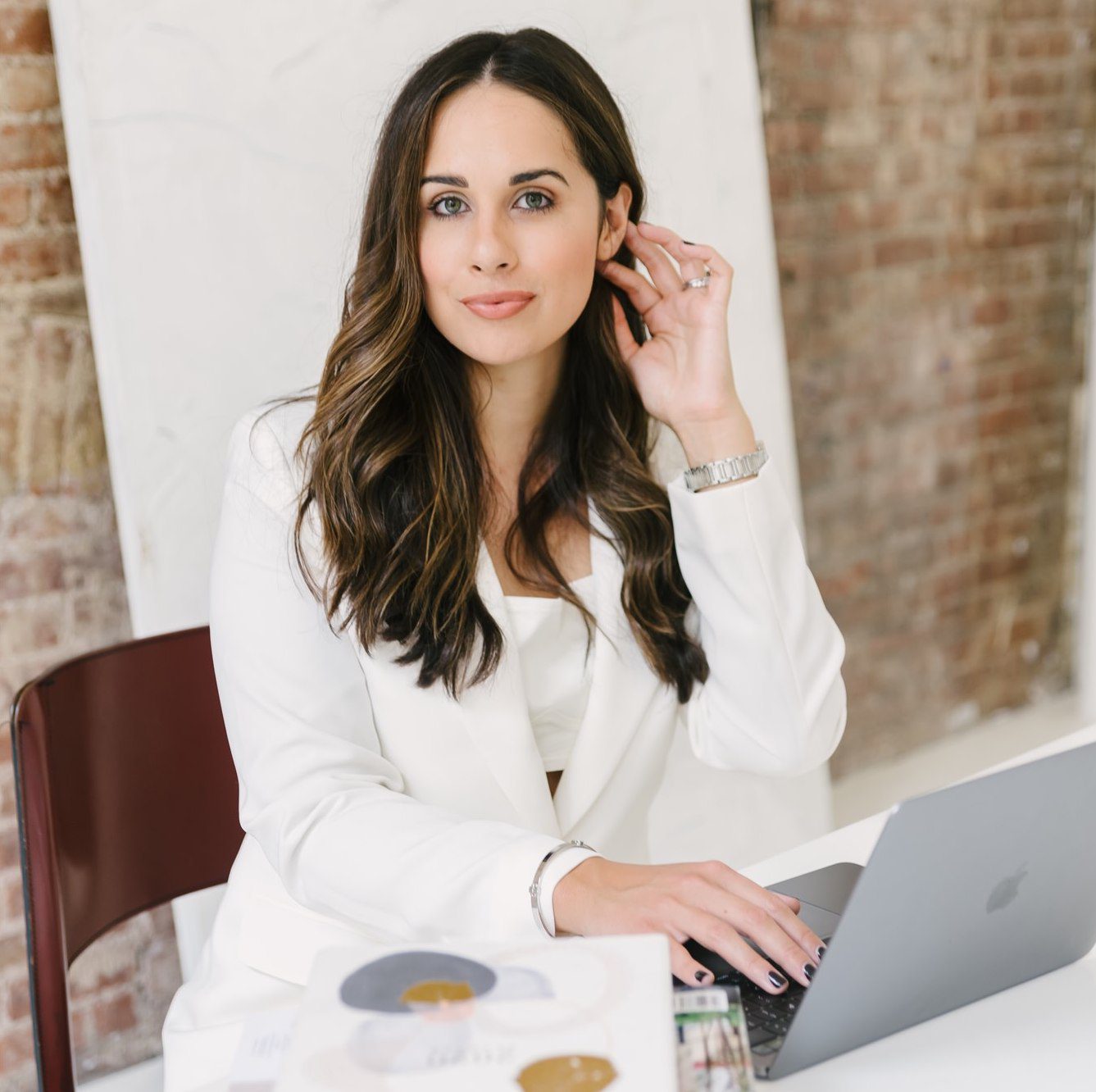 Hannah Nieves Wearing a White Blazer and Holding Her Hair